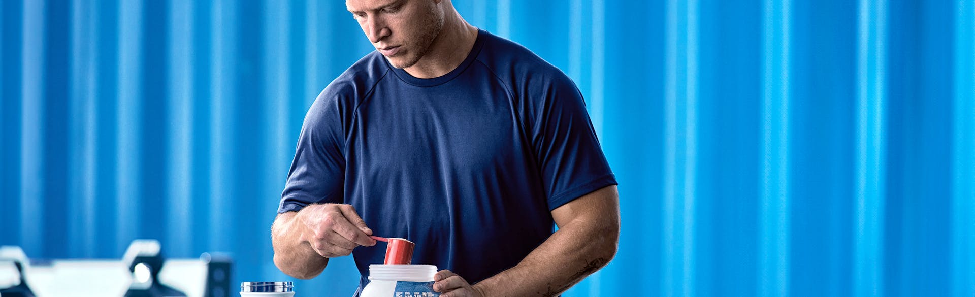 Christian McCaffrey scooping Dymatize ISO100 protein powder into a shake