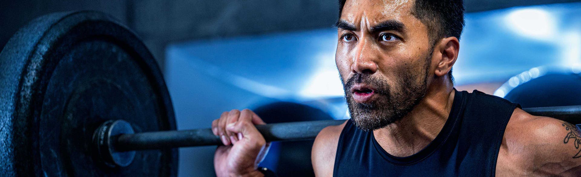 A man lifting weights. He looks very determined.